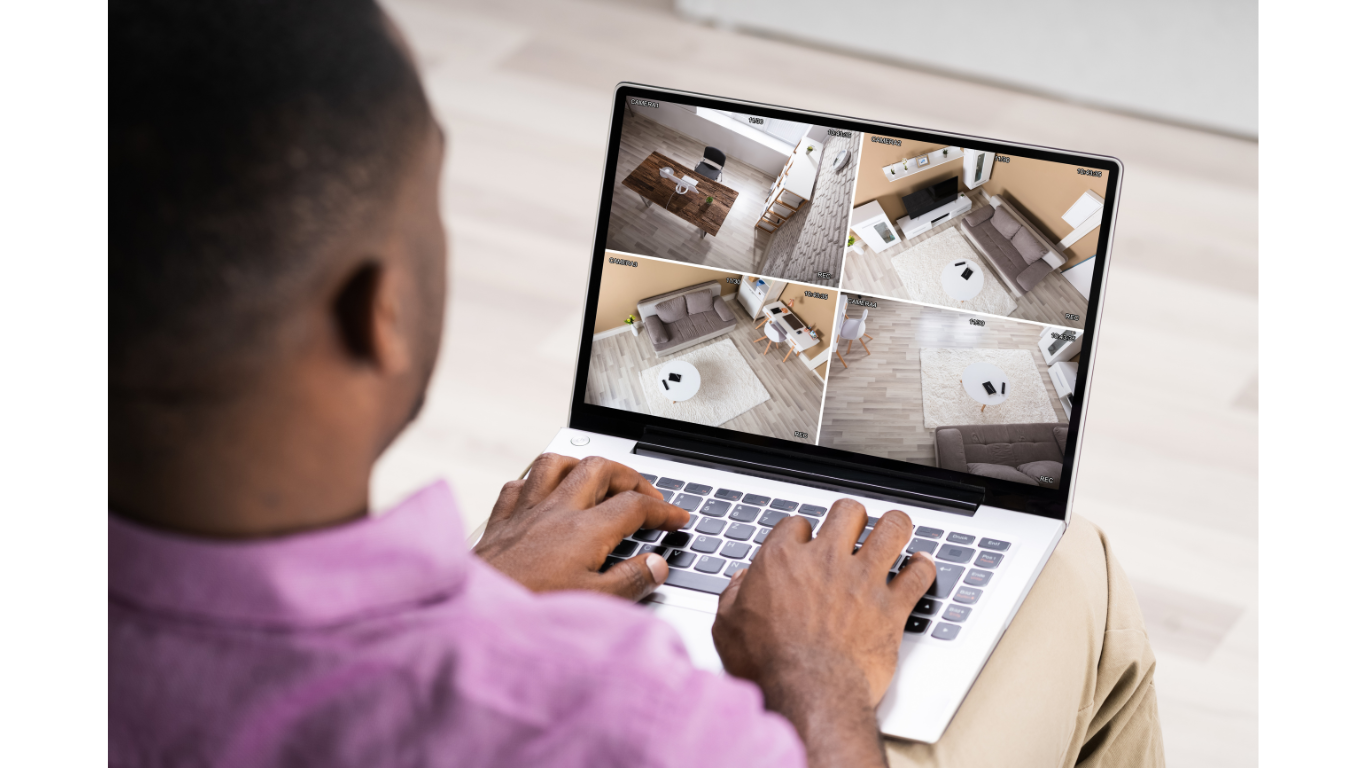 Man looking at cameras of his house interior on a laptop